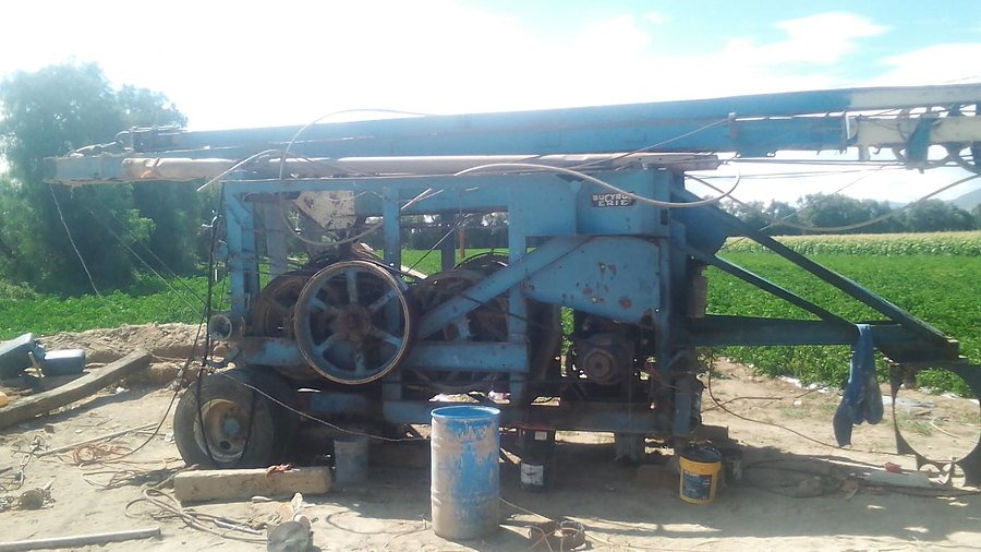 Equipo de perforación instalado junto a zona de cultivo