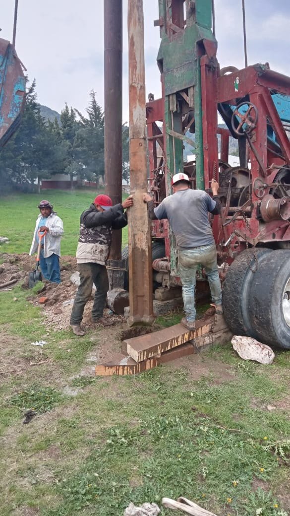 Operarios trabajando al pie de la torre de perforación